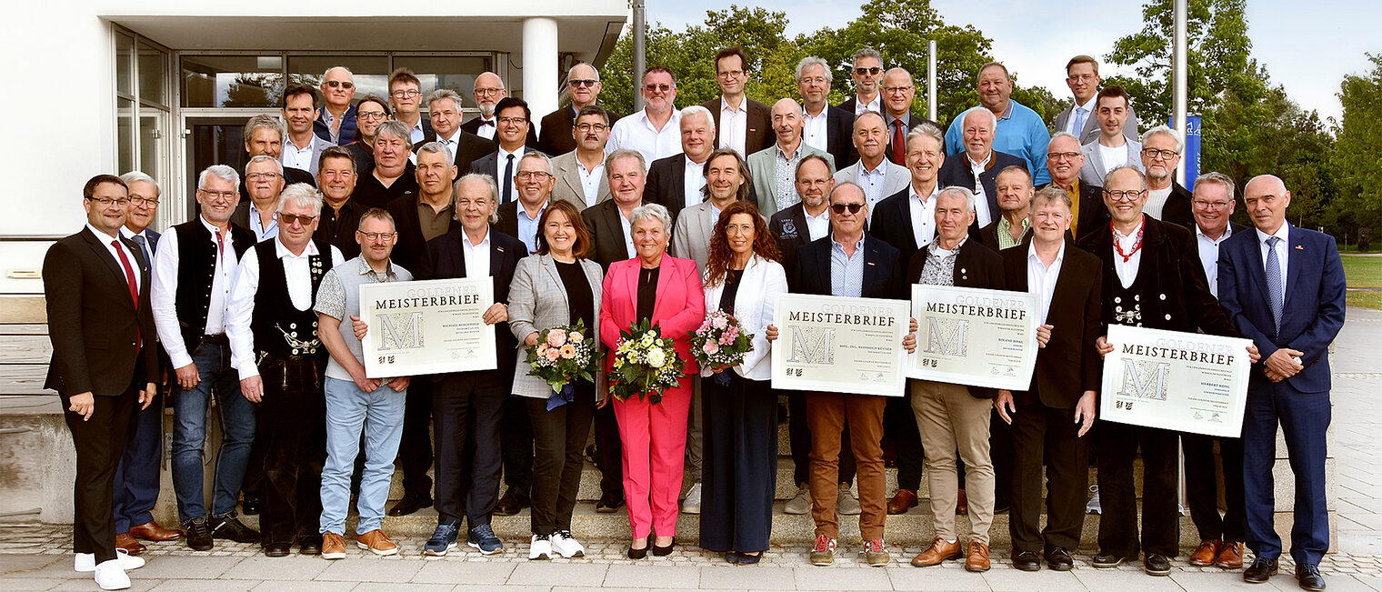 In Amberg ehrte die Handwerkskammer ihre „Goldenen“ Meisterinnen und Meister. Die "Goldenen Meister" freuten sich über ihre Meisterbriefe und das Goldene M. Hier zu sehen mit den Ehrengästen vor dem Gebäude.
